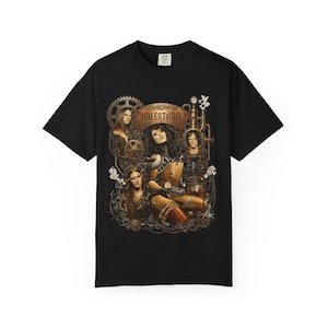 May include: A black short-sleeve t-shirt featuring a graphic print of the band Halestorm. The design includes four figures surrounded by mechanical gears, pipes, and steam elements in shades of brown, gold, and copper against the black fabric.