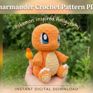 Könnte beinhalten: Ein gehäkeltes orangefarbenes Charmander-Amigurumi, inspiriert von Pokémon, mit blauen Augen und einem Flammenschwanz. Das Bild enthält den Text "Charmander Crochet Pattern PDF" und "Instant Digital Download".