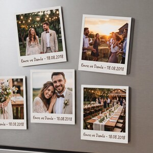 May include: Five square magnets displaying wedding photographs, attached to a stainless steel fridge. Each magnet features a different image from a wedding, with the text "Emre ve Damla - 18.08.2018" printed on each.