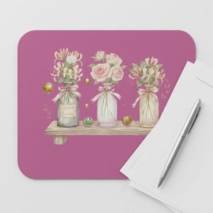 May include: A decorative mousepad featuring a watercolor illustration of three glass bottles with flowers. The bottles are tied with pink ribbons and sit on a wooden shelf against a magenta background. Gold and green accents complete the design.