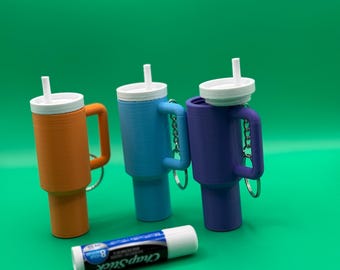 Llavero con forma de bálsamo labial o lápiz labial pequeño.