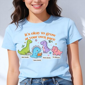 May include: A white ceramic mug with a black handle and the text "But First, Coffee" in a handwritten style. The mug is on a white surface. The mug is approximately 4 inches tall.