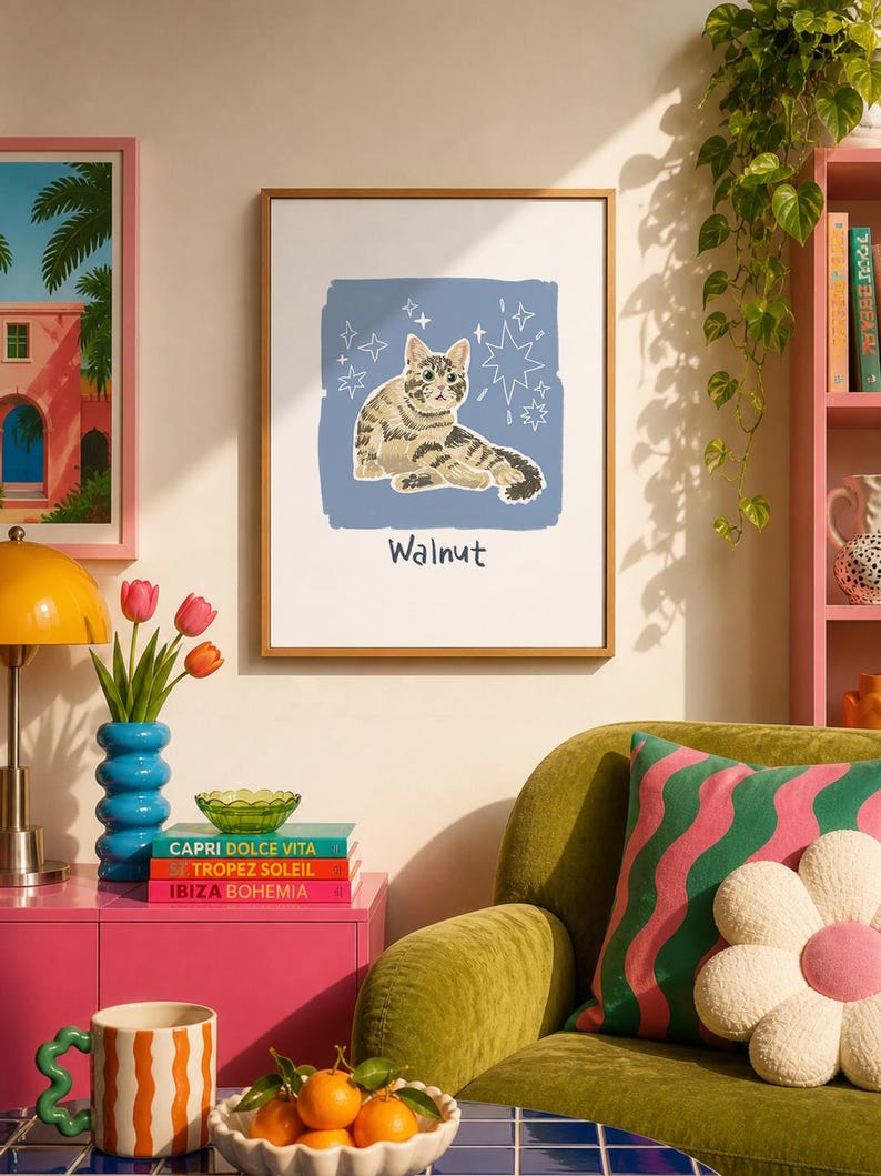 May include: A framed wall art print featuring a brown tabby cat illustration centred on a blue square background with white star accents. The name Walnut is printed in dark blue text below the cat. The print is enclosed in a thin wooden frame.