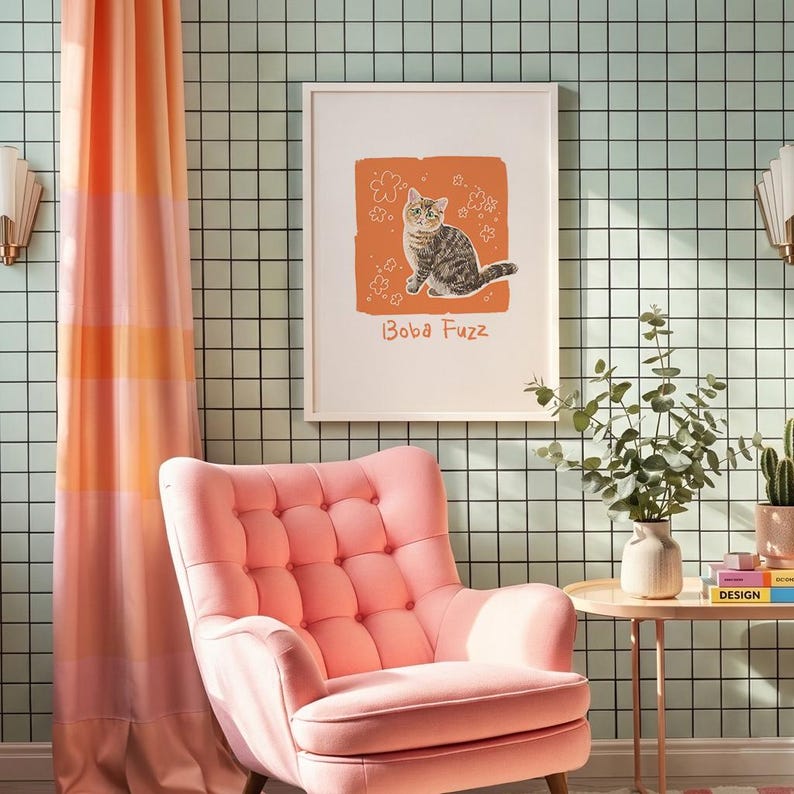 May include: A framed wall art print featuring a brown tabby cat illustration on an orange background with white flower outlines and the text "Boba Fuzz" in a simple font, displayed on a wall with a light green grid pattern.