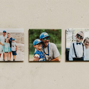 May include: Three square photo prints featuring family portraits. The prints show a family of four, a father and son, and two children in formal wear. The photos are displayed on a neutral background.