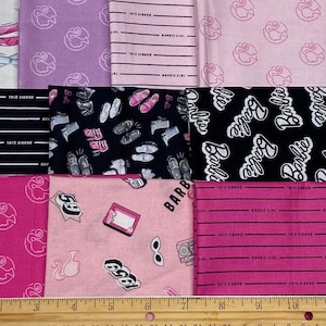 May include: A collection of fabric swatches featuring various Barbie-themed patterns including the Barbie logo, silhouettes, shoes, and the text Barbie Girl. A wooden ruler is visible at the bottom, showing measurements in inches up to 10 inches.