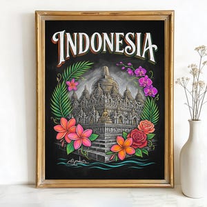 May include: Framed art print featuring the word "INDONESIA" above a detailed illustration of a temple. The artwork is surrounded by colorful flowers and foliage, set against a black background.