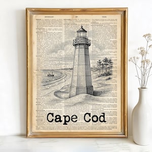 May include: Framed black and white illustration of a lighthouse on a vintage dictionary page. The lighthouse is on a sandy dune with a ship in the distance. The words "Cape Cod" are printed in bold black letters at the bottom of the image.