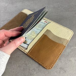 May include: A set of three ceramic mugs with a speckled, matte finish. Each mug features a different color: light blue, cream, and gray. The mugs have a simple, modern design and a comfortable handle.