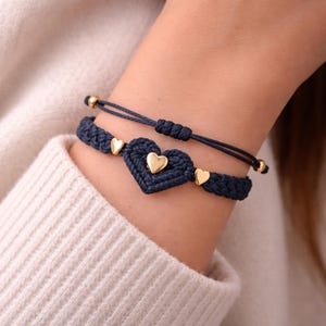 May include: A white ceramic mug with a black handle and the text "But First, Coffee" in a bold, black font. The mug is sitting on a wooden surface. The mug is approximately 4 inches tall.