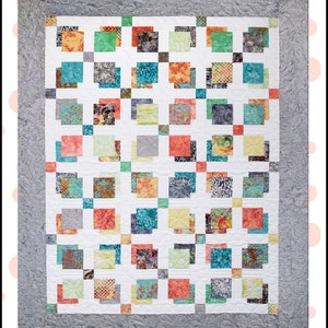 May include: A quilt pattern called "Shadow Dance" by Gersi Richards. The quilt features a geometric design with squares of various colors and patterns, including teal, coral, yellow, and gray. The quilt is surrounded by a gray border.