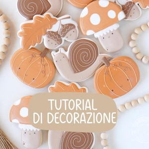 Può includere: Una collezione di biscotti a tema autunnale a forma di zucche, lumache, funghi, ghiande e foglie di quercia, decorati con glassa nei toni dell'arancione, marrone e crema. Un riquadro rettangolare beige riporta il testo TUTORIAL DI DECORAZIONE.