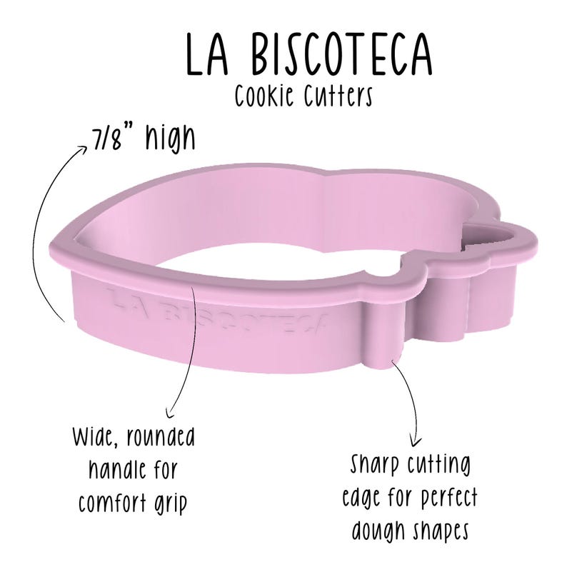 May include: A light pink cookie cutter in the shape of a heart with a wide, rounded handle for a comfortable grip. The cutter is 7/8" high and has a sharp cutting edge for perfect dough shapes. The text "LA BISCOTECA Cookie Cutters" is visible.