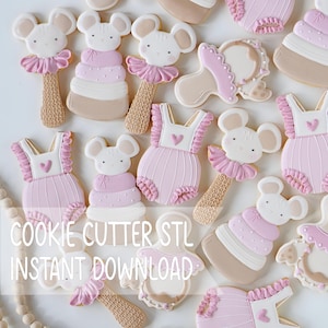 May include: A collection of decorated cookies shaped like baby rattles with mouse heads, tiered stacking rings, and ruffled rompers with heart accents. The cookies feature a color palette of soft pink, white, and tan. Text reads COOKIE CUTTER STL INSTANT DOWNLOAD.