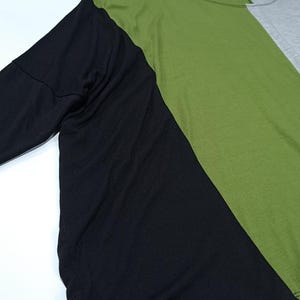 Pu&ograve; includere: Una maglietta a maniche lunghe con un design a blocchi di colore. La maglietta &egrave; divisa in tre sezioni: una manica nera, un busto verde e una sezione grigia. La maglietta &egrave; realizzata in un materiale morbido e confortevole.