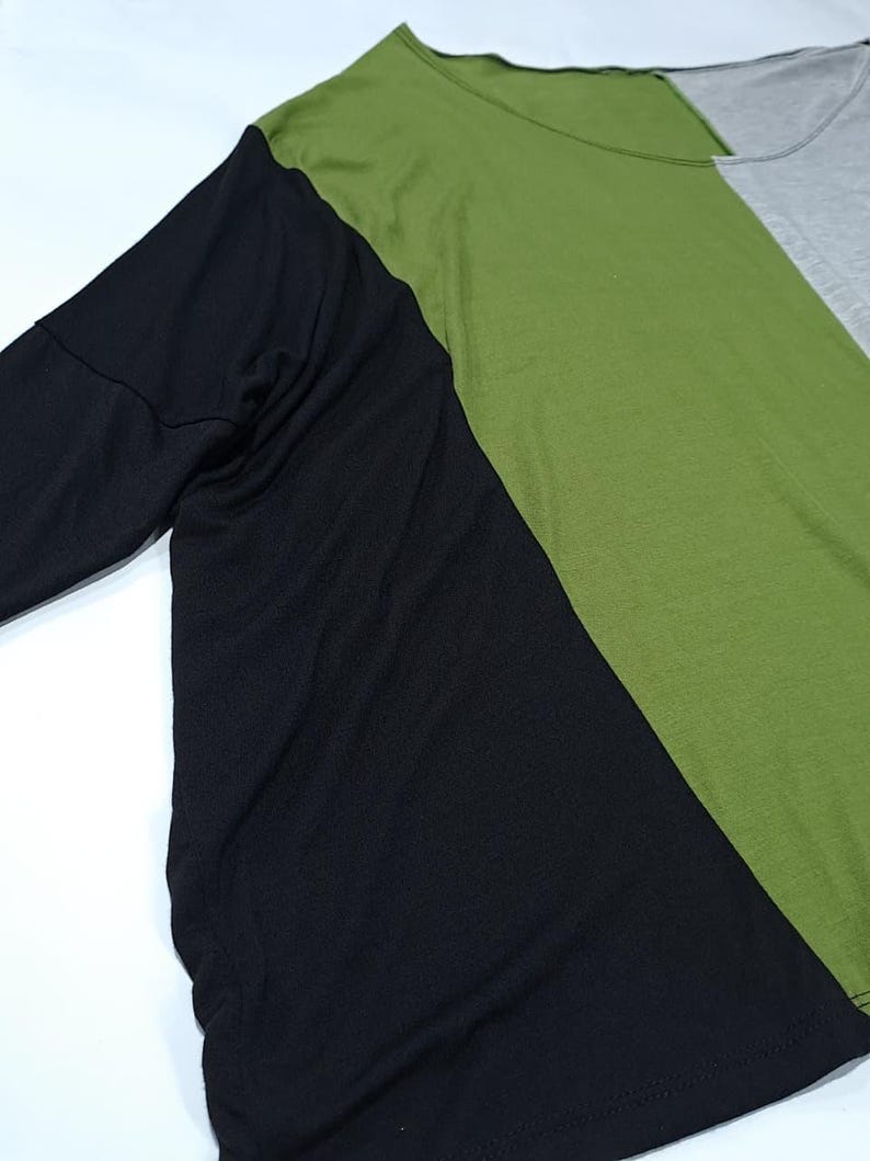 Pu&ograve; includere: Una maglietta a maniche lunghe con un design a blocchi di colore. La maglietta &egrave; divisa in tre sezioni: una manica nera, un busto verde e una sezione grigia. La maglietta &egrave; realizzata in un materiale morbido e confortevole.
