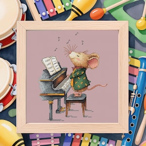 May include: A framed cross-stitch depicts a mouse playing a piano, wearing a green jacket. Musical notes float above the mouse. The background includes various musical instruments like drums, maracas, and a xylophone, all in a colorful arrangement.
