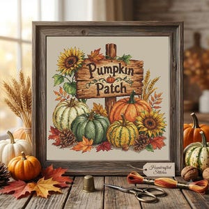 May include: A framed cross-stitch embroidery featuring a wooden sign with the text Pumpkin Patch, surrounded by sunflowers, various pumpkins in green, orange, and yellow, autumn leaves, and pinecones on a light beige fabric background.
