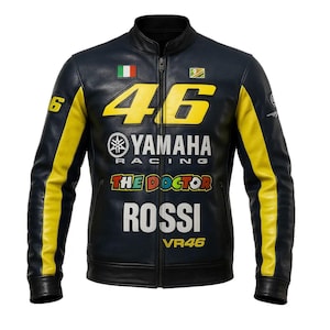 Puede incluir: Chaqueta de cuero negra con detalles amarillos y blancos. La chaqueta presenta el número "46" en amarillo, el logotipo de Yamaha Racing y el nombre "ROSSI" en blanco. También se ve el texto "THE DOCTOR".