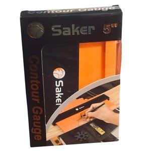 May include: A black rectangular product box for a Saker 5-inch contour gauge. The packaging features the text Contour Gauge and Saker, with a graphic showing an orange contour gauge tool being used to trace a shape onto a piece of wood.