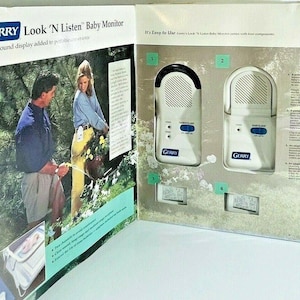 May include: A white and black Gerry Look 'N Listen baby monitor with two units. The monitor has a visual sound display. The box also shows a couple watering plants in a garden.