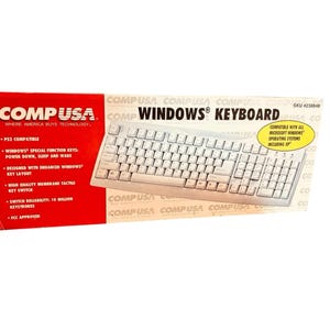 May include: A white computer keyboard in its original retail packaging. The box features the CompUSA logo, the text Windows Keyboard, and lists features including PS2 compatibility, special function keys, and a 10 million keystroke reliability.