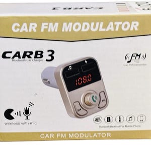 May include: A rectangular white and gold box for a CARB 3 Bluetooth car charger and FM modulator. The packaging displays the product, which is a silver device with a digital display showing 108.0, a central dial, and buttons for music control.