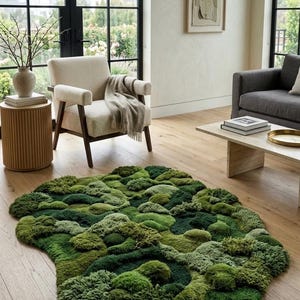 May include: A unique, irregularly shaped rug with a textured surface, featuring a variety of green shades. The rug's design resembles a mossy landscape, adding a natural element to the room. The rug is placed on a hardwood floor.