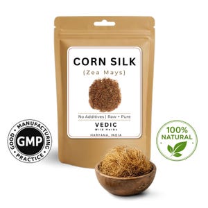 May include: A tan pouch labelled "CORN SILK (Zea Mays)" containing a brown, fibrous material. A small wooden bowl holds a similar substance. The text "No Additives | Raw + Pure" is visible. A "100% NATURAL" seal is present.
