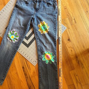 Levi-jeans met ingezette bloemen voor een uniek geüpcycled item. afbeelding 3