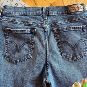 Levi-jeans met ingezette bloemen voor een uniek geüpcycled item. afbeelding 6