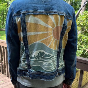Denim jacket featuring a sun and waves back panel.