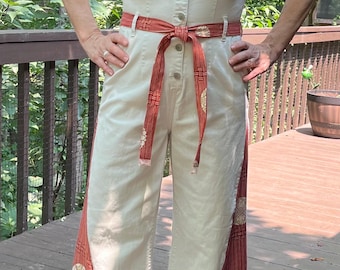 Een funky jumpsuit met wijde pijpen, geïnspireerd op de jaren 70, is opgeknapt met leuke driehoekige stoffen inzetstukken, een riem en een kraag.