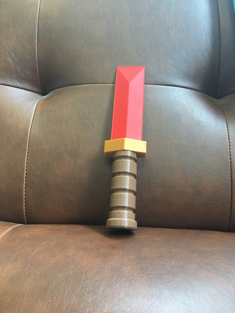 May include: A red and brown plastic toy sword with a textured handle.