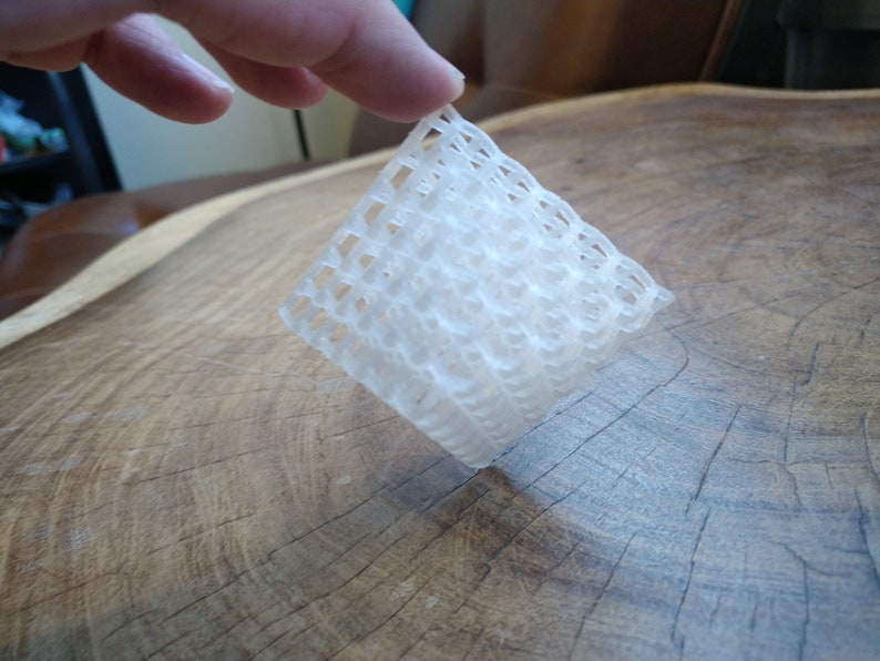 Puede incluir: Una l&aacute;mina de malla de pl&aacute;stico blanco con forma cuadrada y un patr&oacute;n tejido.