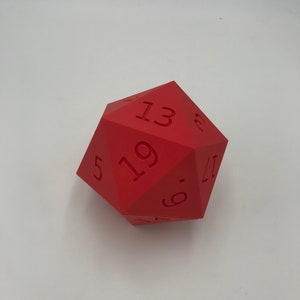 May include: A red twenty-sided die with the numbers 5, 6, 11, 13, 17, and 19 visible.