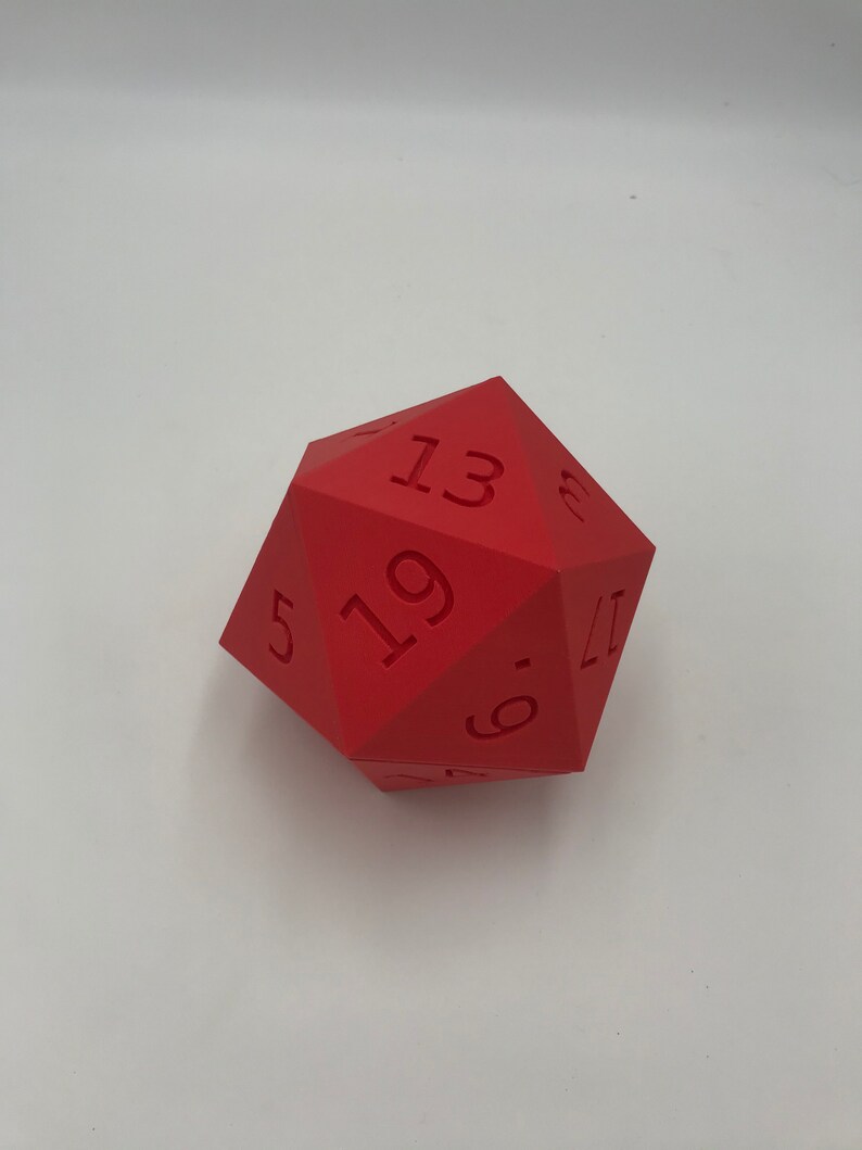 May include: A red twenty-sided die with the numbers 5, 6, 11, 13, 17, and 19 visible.