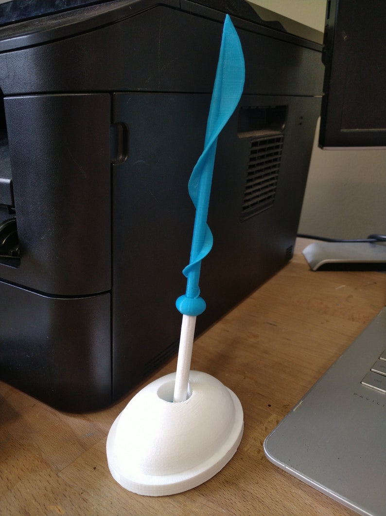 May include: A blue plastic sword with a white base. The sword is twisted and has a rounded tip. The base is a simple oval shape.