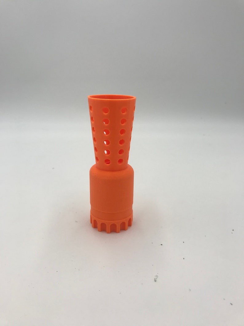 以下が含まれることがあります： オレンジ色のプラスチック製の3Dプリントオブジェクト。円筒形のベースと、穴の開いた円錐形のトップを持っています。このオブジェクトは、3Dプリントオブジェクトのディフューザーとして使用するために設計されています。