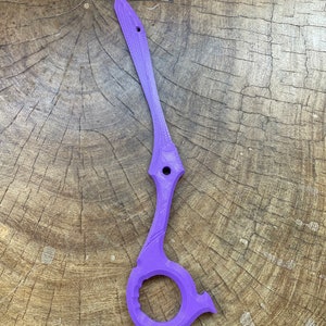 May include: A purple plastic tool with a ring on the bottom and a pointed end. The tool is designed to open packages and other items.