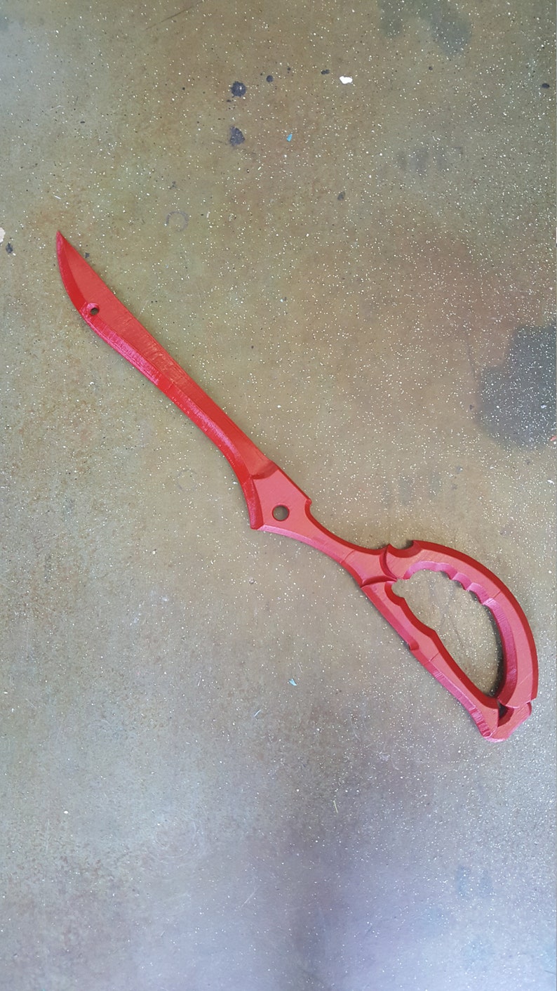 May include: A red plastic prop scissor with a detailed handle. The scissor is a replica of a popular anime weapon.
