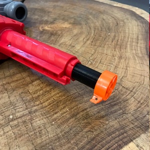 Peut inclure: Un jouet pistolet rouge et noir avec un embout orange. Le pistolet a une poign&eacute;e textur&eacute;e et un canon noir.