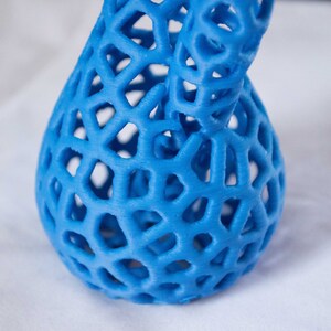 May include: A blue 3D printed vase with a lattice design. The vase is made of plastic and has a smooth, glossy finish.