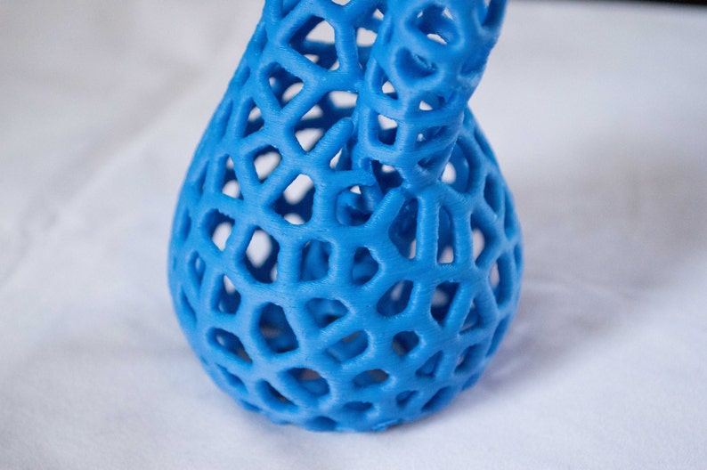 May include: A blue 3D printed vase with a lattice design. The vase is made of plastic and has a smooth, glossy finish.