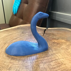 K&ouml;nnte beinhalten: Eine blaue 3D-gedruckte Figur eines Fabelwesens mit langem Hals und rundem K&ouml;rper.
