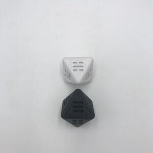 May include: Two geometric dice, one black and one white, with a unique design on each face. The dice are made of a textured material and are perfect for tabletop games.