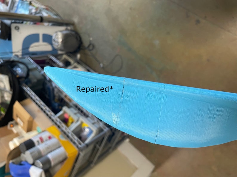 Puede incluir: Primer plano de un objeto de pl&aacute;stico azul claro, curvo, con una grieta reparada. El texto "Reparado*" est&aacute; escrito en el objeto.