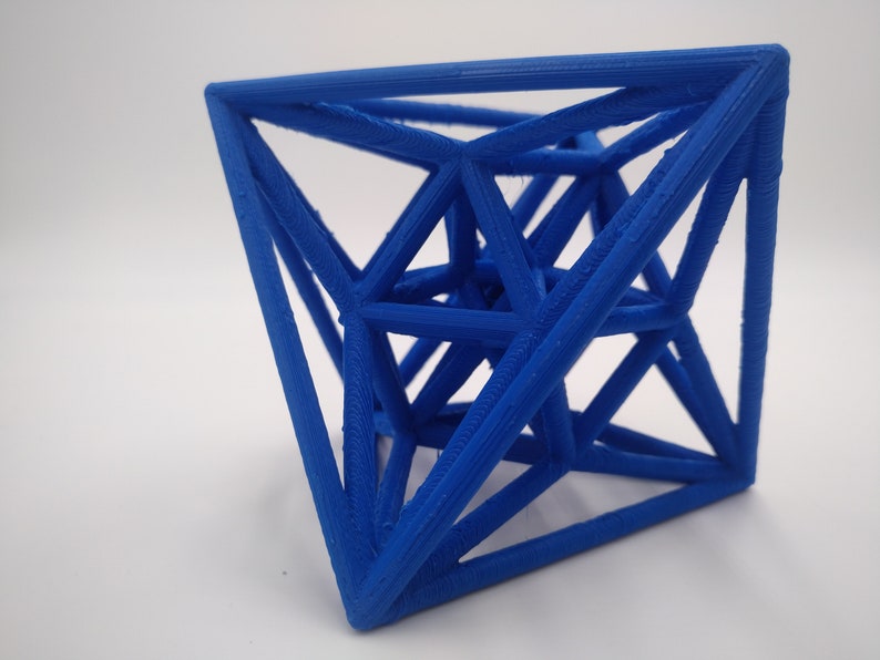 May include: A blue 3D printed geometric shape with a complex, intricate design. The shape is made up of many interconnected triangles and appears to be a stellated octahedron.