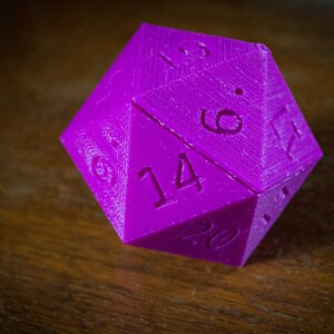 May include: A purple 20-sided die with the numbers 14, 6, 19, and 20 visible.