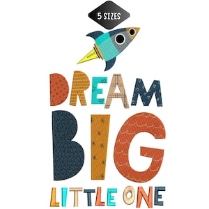 以下が含まれることがあります： さまざまな模様のフォントで「DREAM BIG LITTLE ONE」という言葉が書かれたカラフルなグラフィック。ロケットのグラフィックが「DREAM」という単語の上にあります。上部には「5 SIZES」というテキストが入った黒いひし形があります。